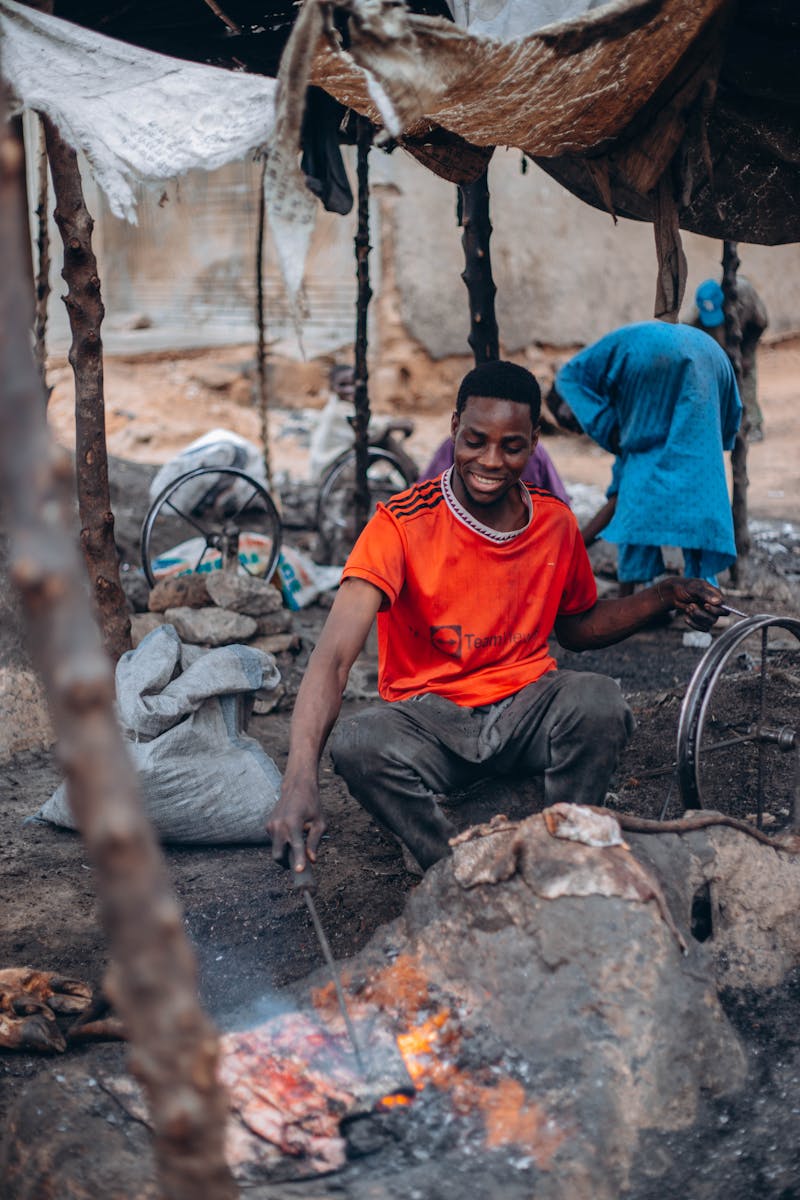 Datoga blacksmith forging metal with traditional tools